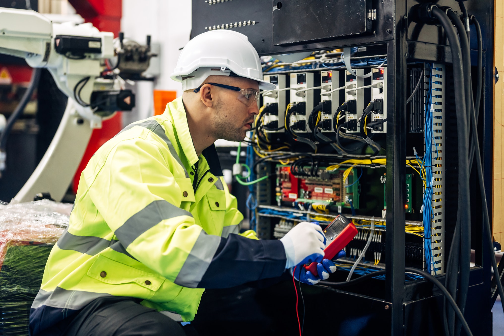 Technician engineer holding robot controller checking automatic robotic machine